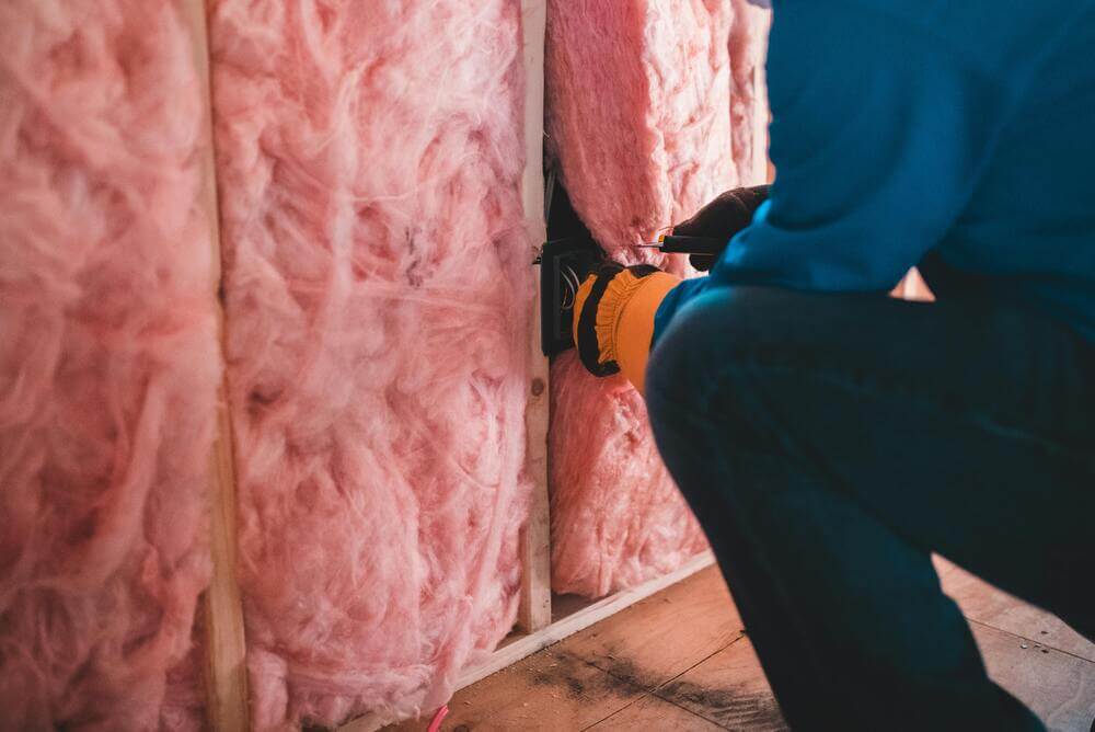 Insulate your walls. Man installing wall insulation.