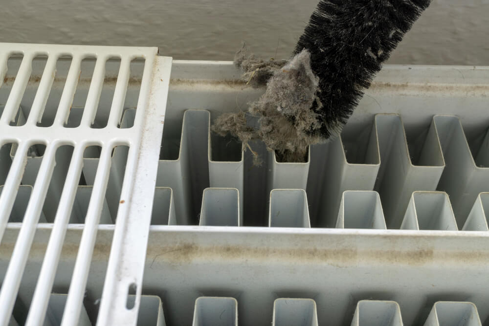 Close up of someone cleaning between radiator fins